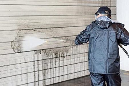 工進（KOSHIN） 農業用エンジン式高圧洗浄機 を使い壁を洗浄している男性